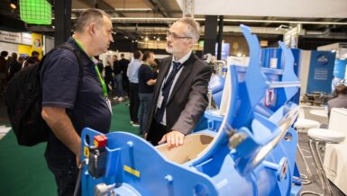 Exposant en bezoeker in gesprek bij een blauwe procesinstallatie op de beursvloer van Solids Antwerpen